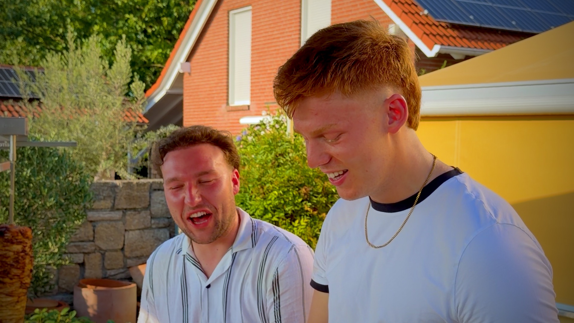 Marc und Lukas lachen an der ALMANS Station und bauen Döner